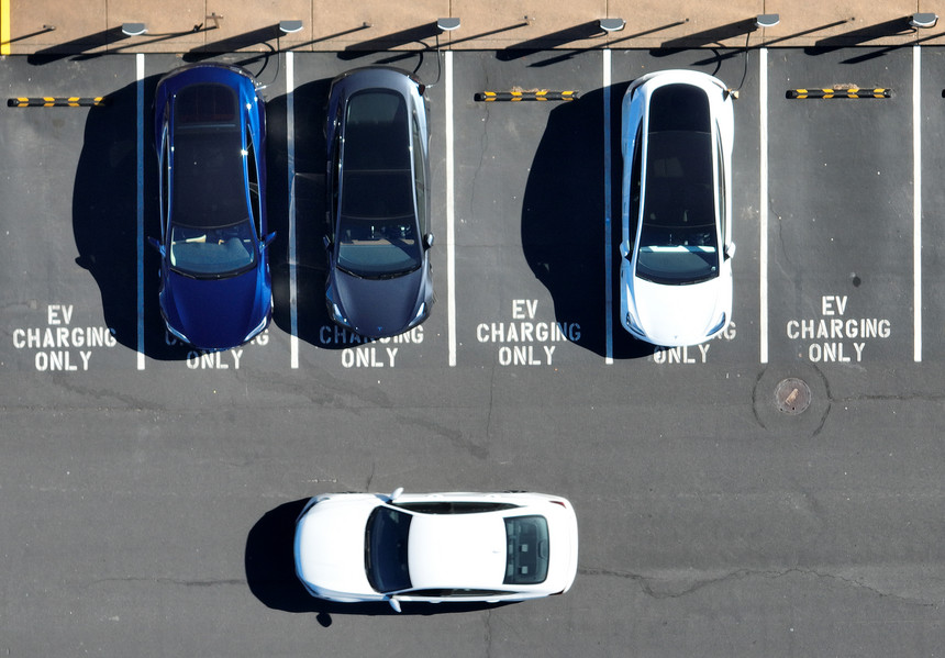 In an aerial view, Tesla cars recharge at a Tesla charger station.